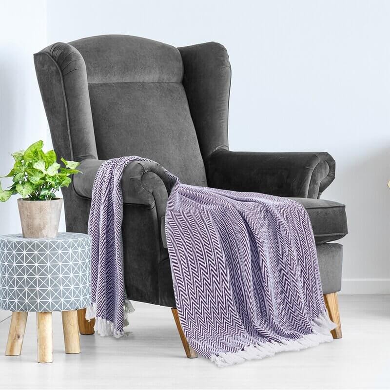 Grey chair with blue throw blanket.
