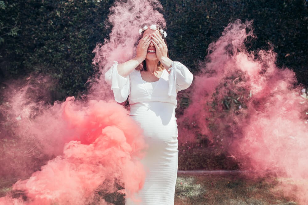 Woman closing her eyes with pink smoke all around her