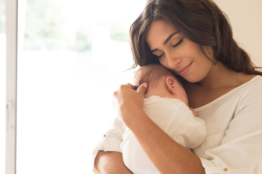 Woman snuggling with her baby