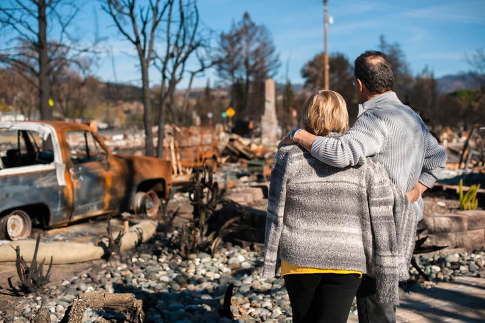 Man and woman looking onto total devastation