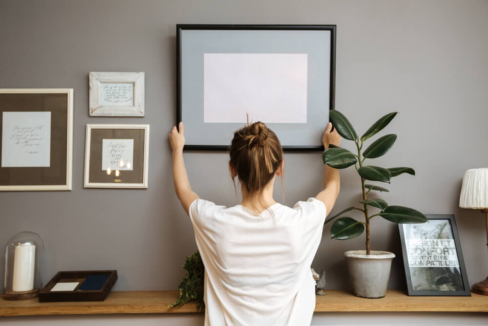 Woman hanging up picture