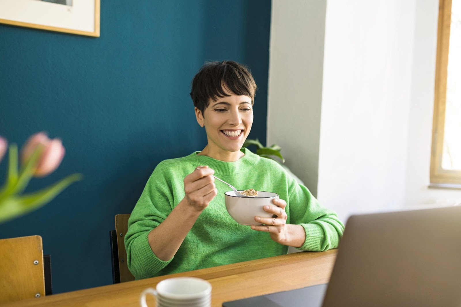 An employee enjoying a lunch and learn with her colleagues on a virtual call.