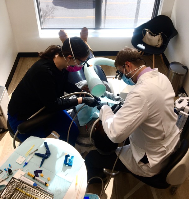 a woman patient in dental chair talking to woman hygienist