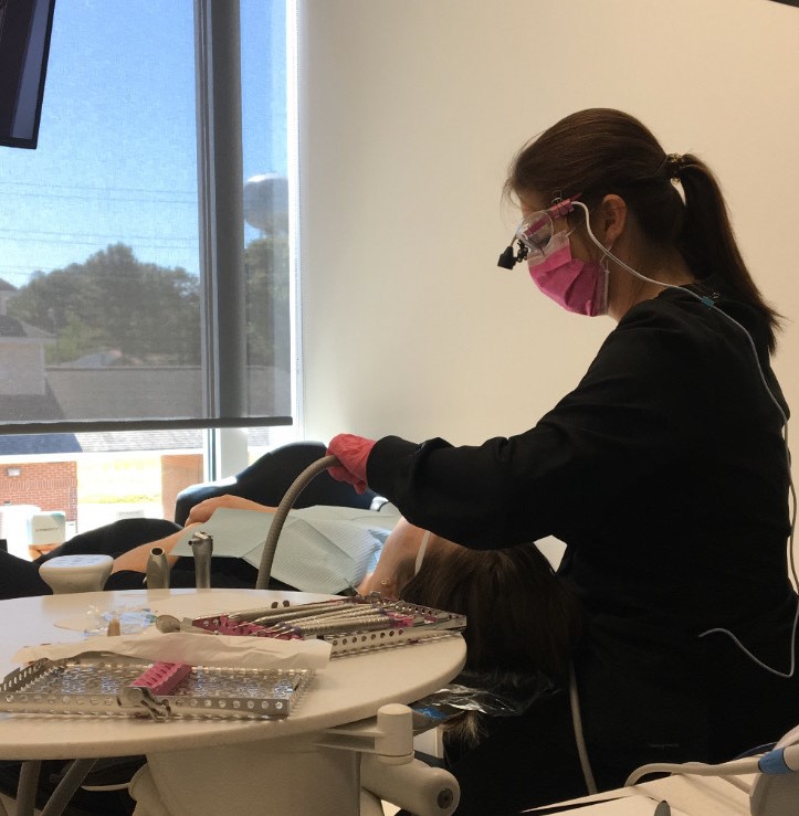 dental hygienist checking out a male patient's teeth