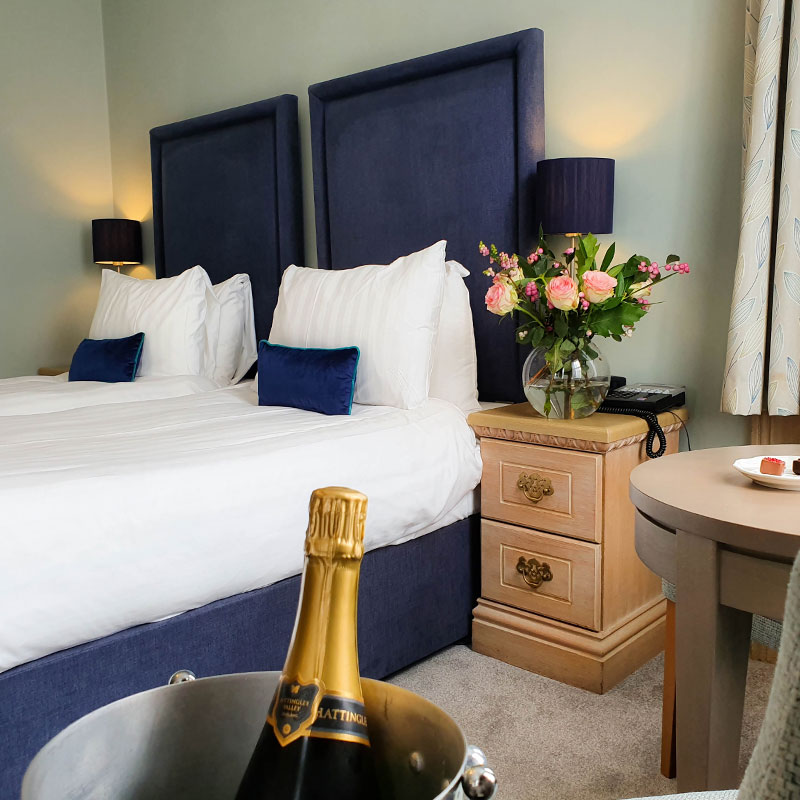 Twin beds in hotel bedroom with champagne bottle