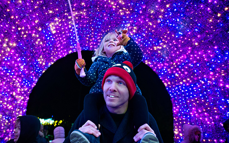 father and daughter walking through the Bournemouth Christmas tree of lights