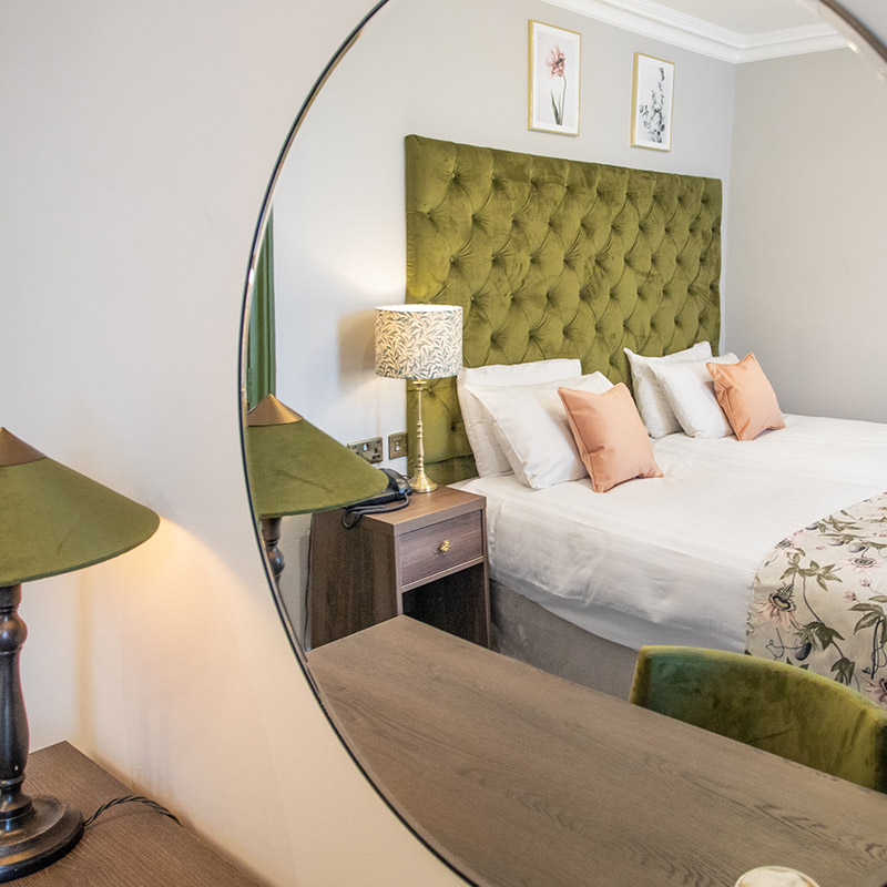 Bournemouth hotel double bedroom with bedside lamps and phone. decorated with two botanical paintings above the bed