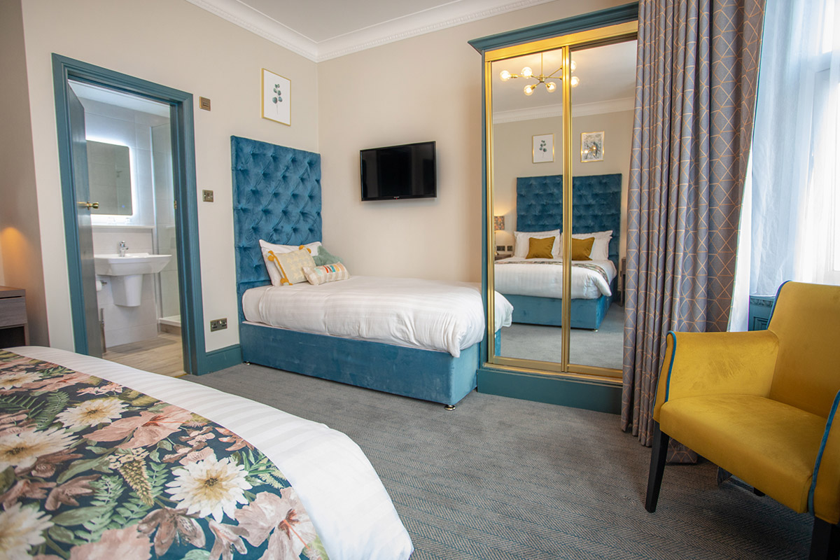 Bournemouth hotel double bedroom with bedside lamps and phone. decorated with two botanical paintings above the bed