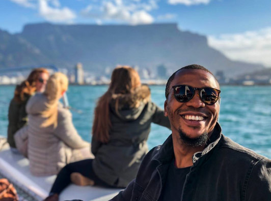 Photogenic Phil sitting on a catamaran with Table Mountain in the distance.