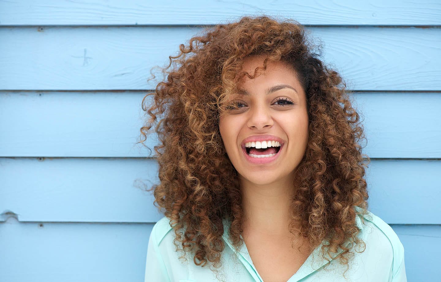 woman smiling by blue wall