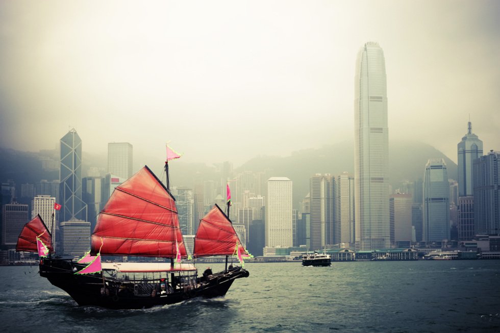 En tradisjonell djunk seiler gjennom travle Victoria Harbour