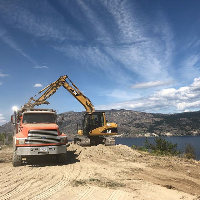Loading a dump truck with a hoe.