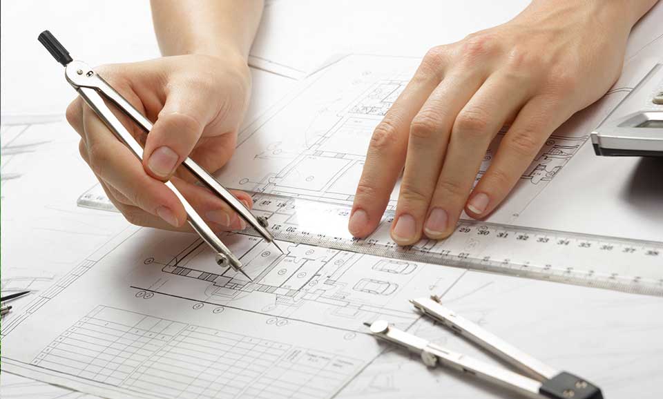 Close up of hands measuring distance on blueprint