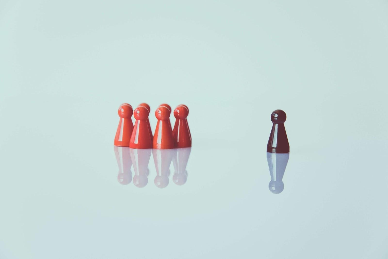 Game pieces displaying laissez faire leadership with one piece set apart