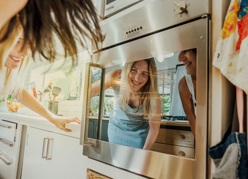 happy couple cooking in the oven after cleaning