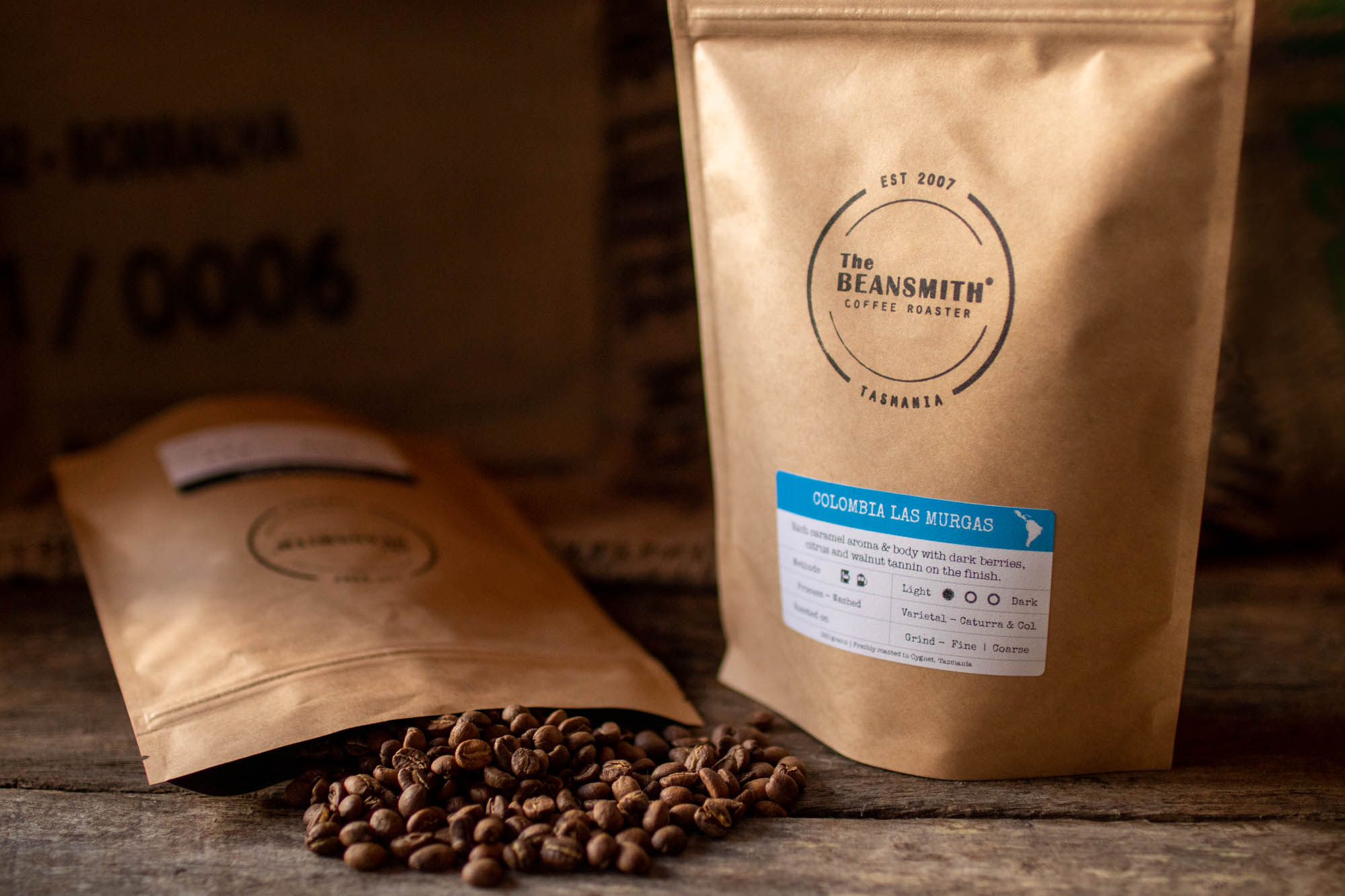 Close up picture of two Beansmith coffee bags. One on its side with coffee spilling out.