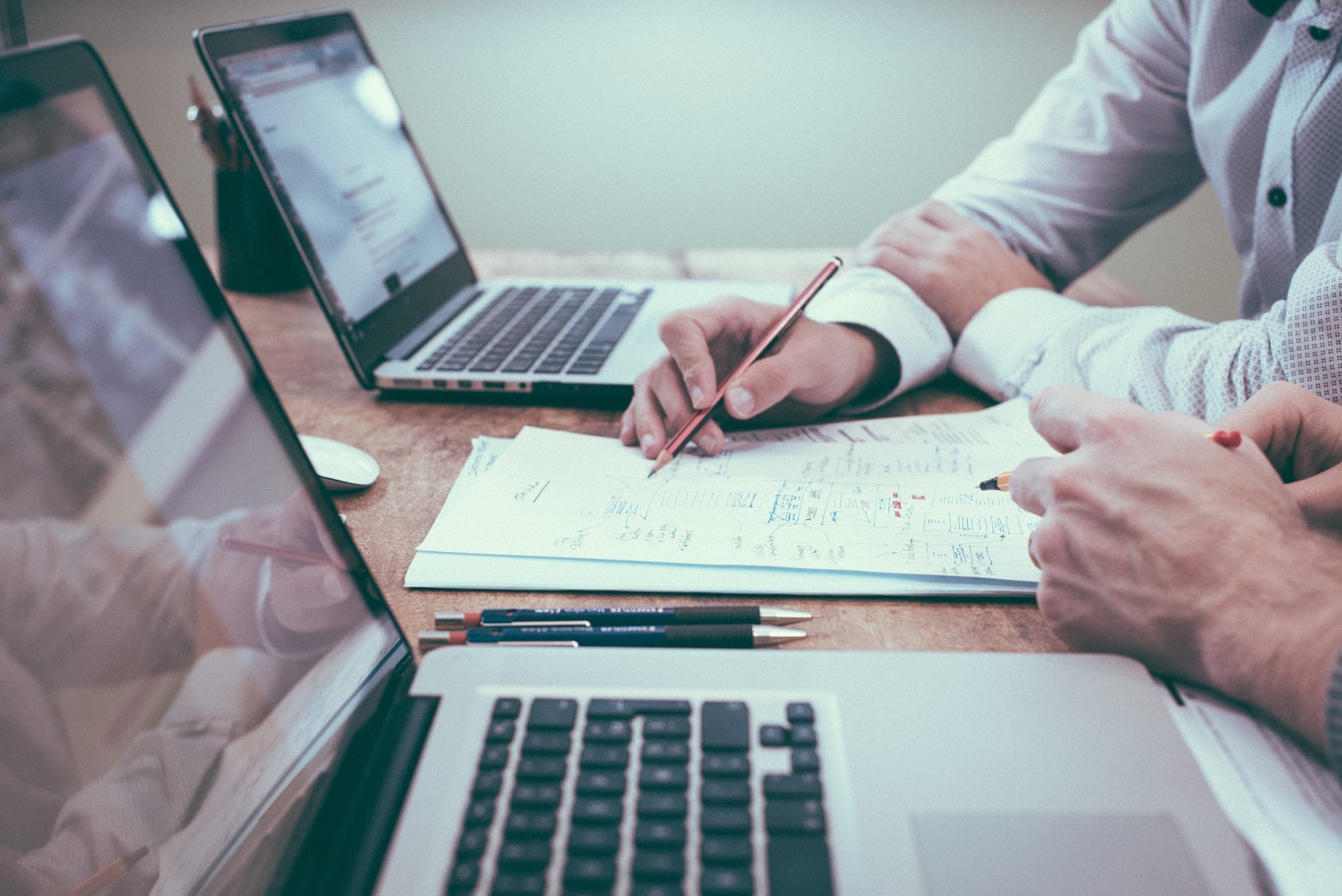 Personnes travaillant sur un bureau avec ordinateurs devant eux