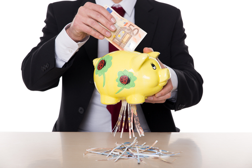 Homem de terno colocando uma nota de euro em um porco e a nota saindo rasgada