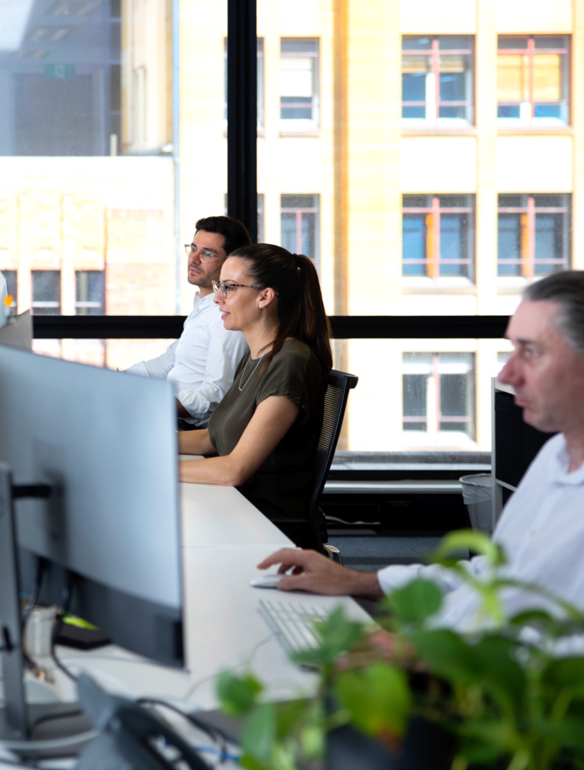 Designate team members working at computers in studio.