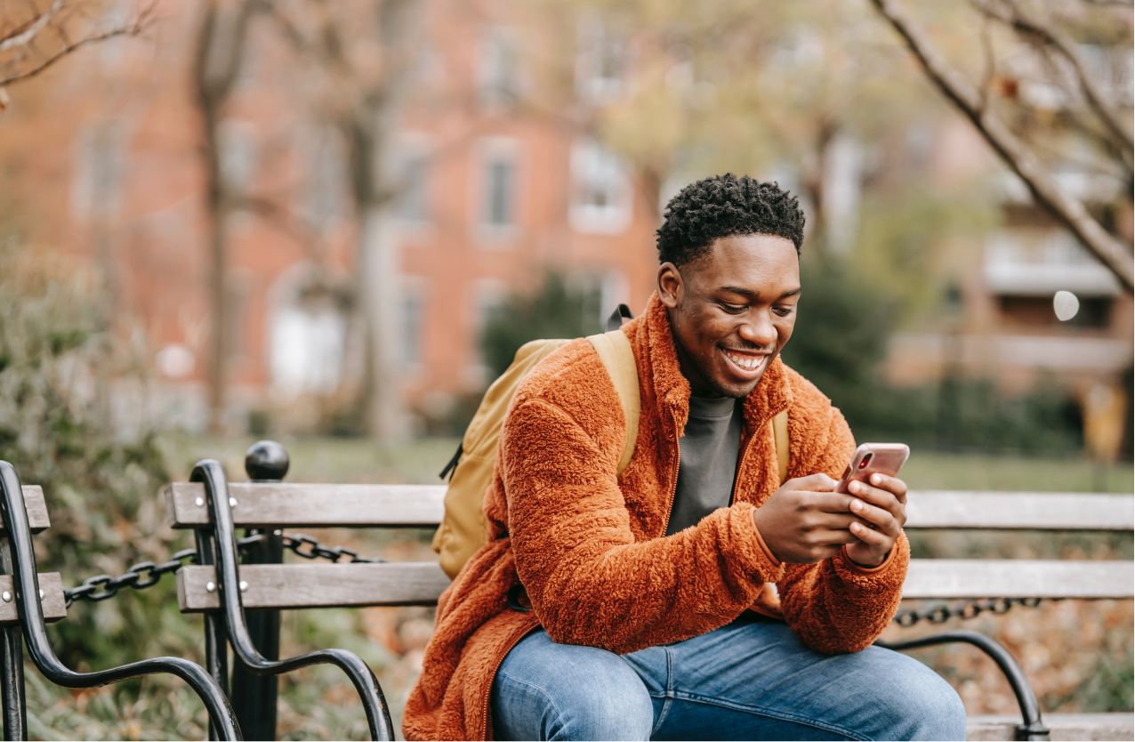 Man in a park with epilepsy looking at his mobile phone