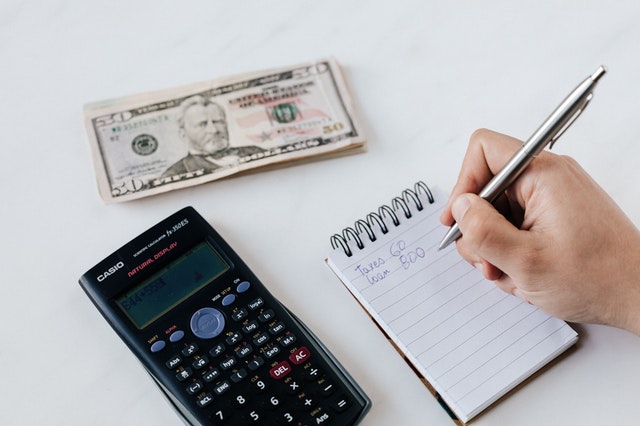 handwriting monthly budget on notepad with calculate and money