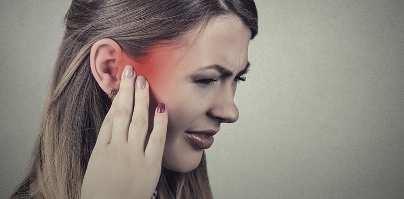 Woman suffering with ear infection pain