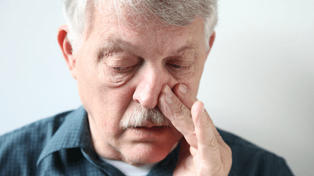 Man trying to breathe through his nose, suffering nasal blockage