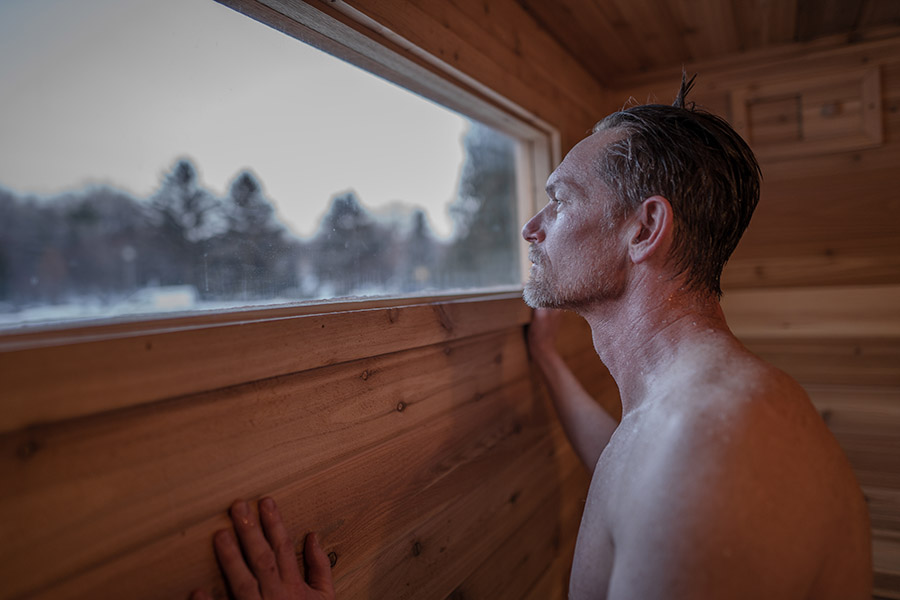 Man looking out of the window of a mobile sauna