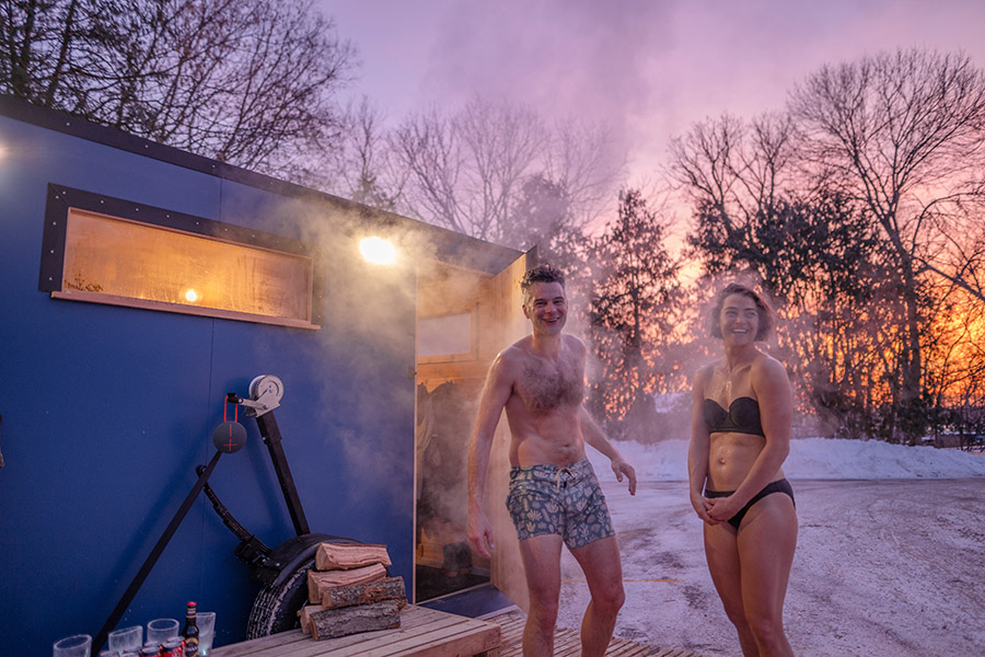 Two people exiting a mobile sauna
