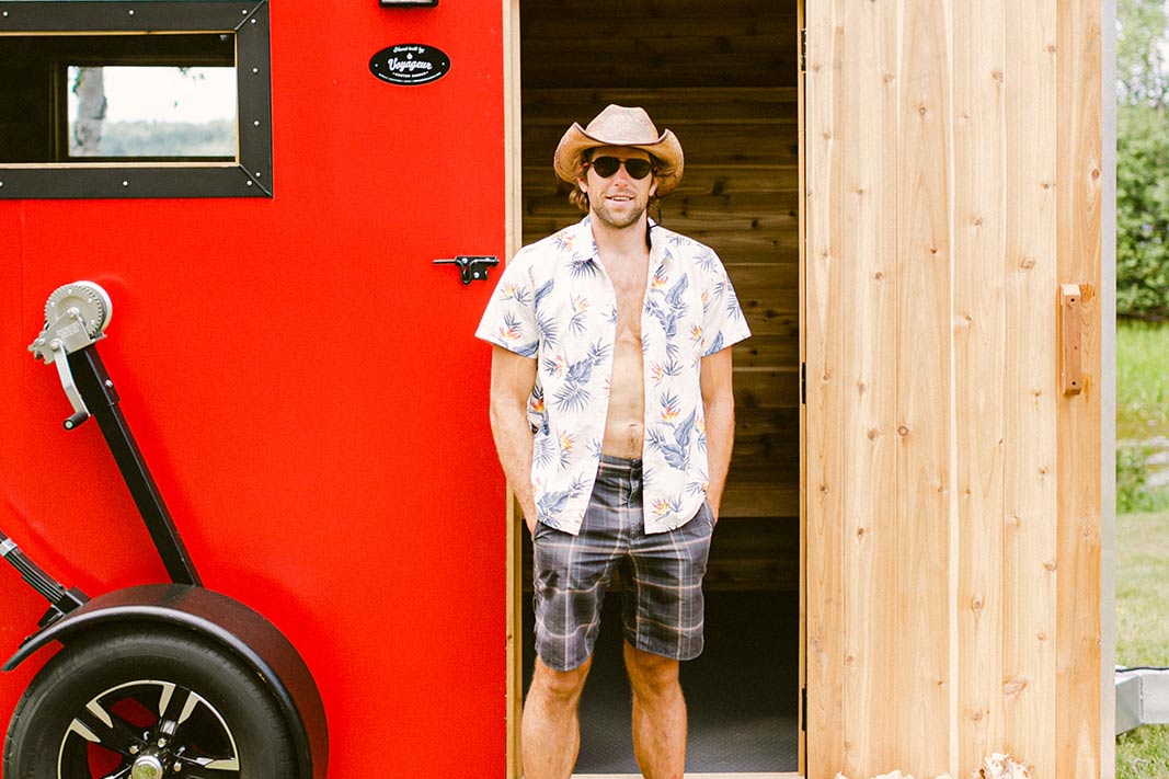 Two people standing outside of a mobile sauna