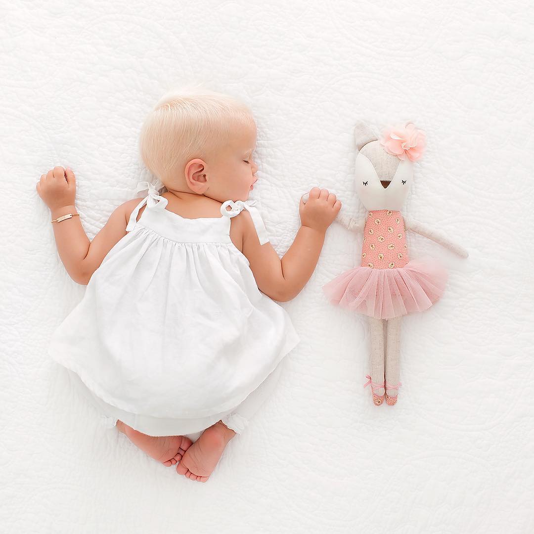 foto de menina na cama com boneca bailarina