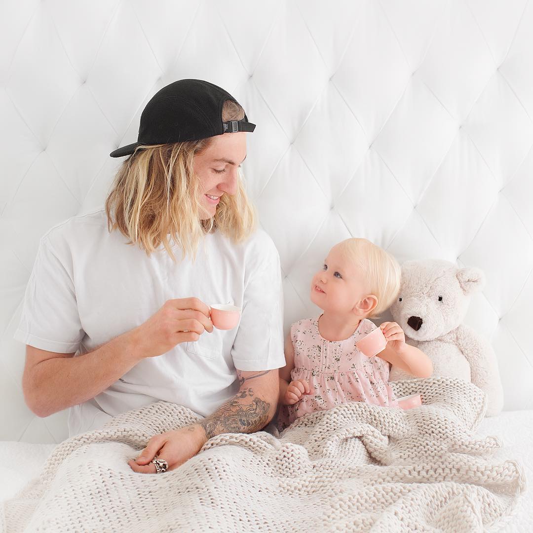 Foto de irmão mais velho tomando chá na cama com a irmã mais nova e bicho de pelúcia