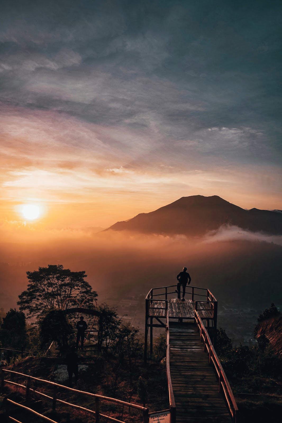 Foto do homem ao nascer do sol no miradouro do Monte Batur de Bali