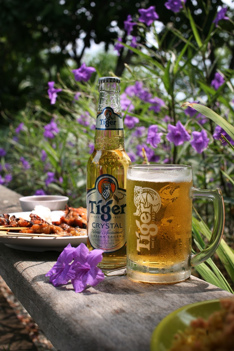Cena de jantar ao ar livre com cerveja Tiger Crystal e flores da primavera