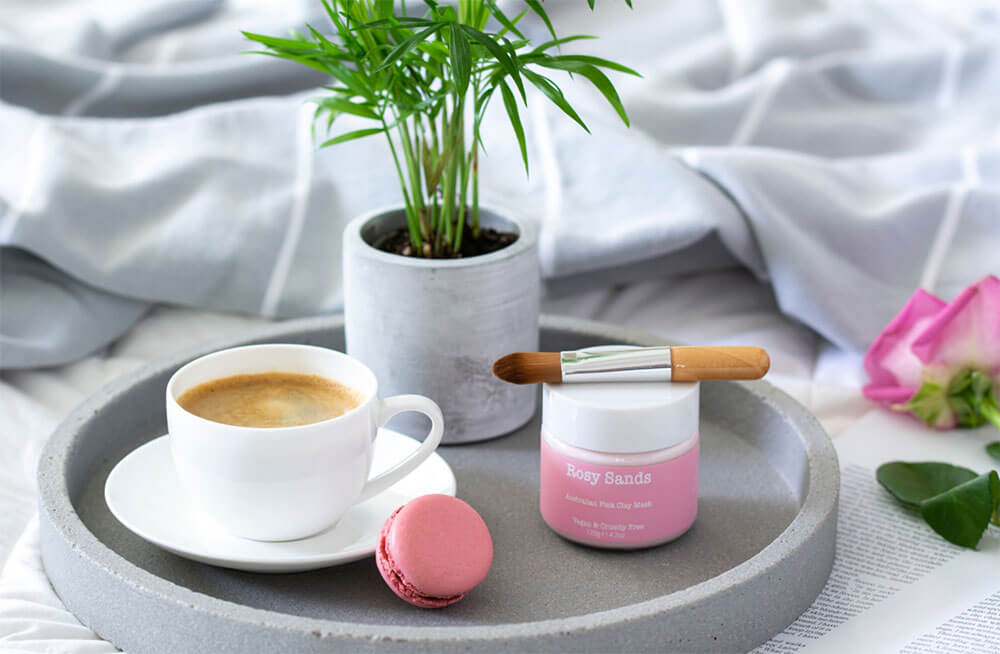 sessão de mimos na cama com café, macaroons e produtos de beleza
