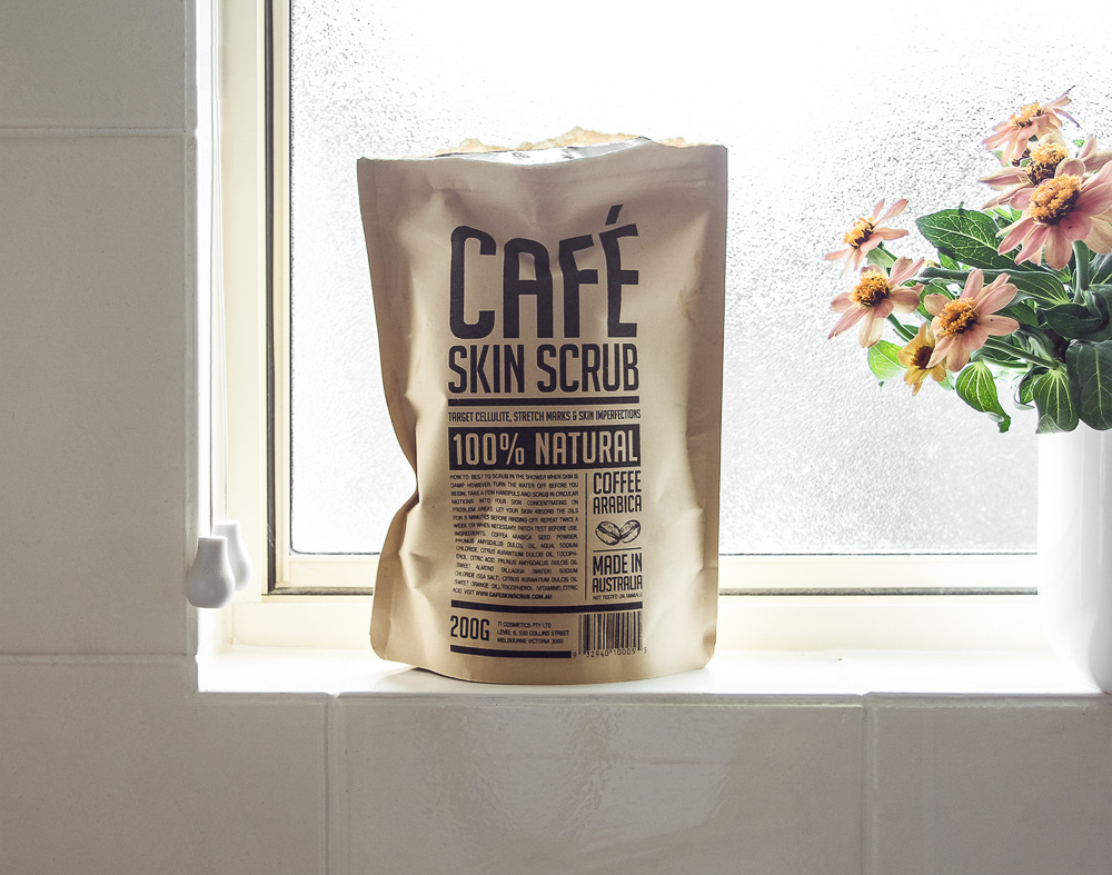 Esfoliante de café no peitoril da janela com vaso de flores