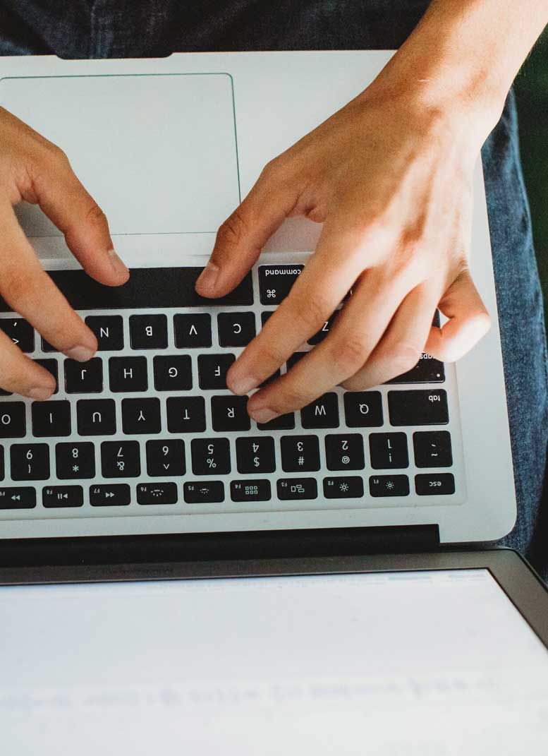 Close up photo of hands using a computer