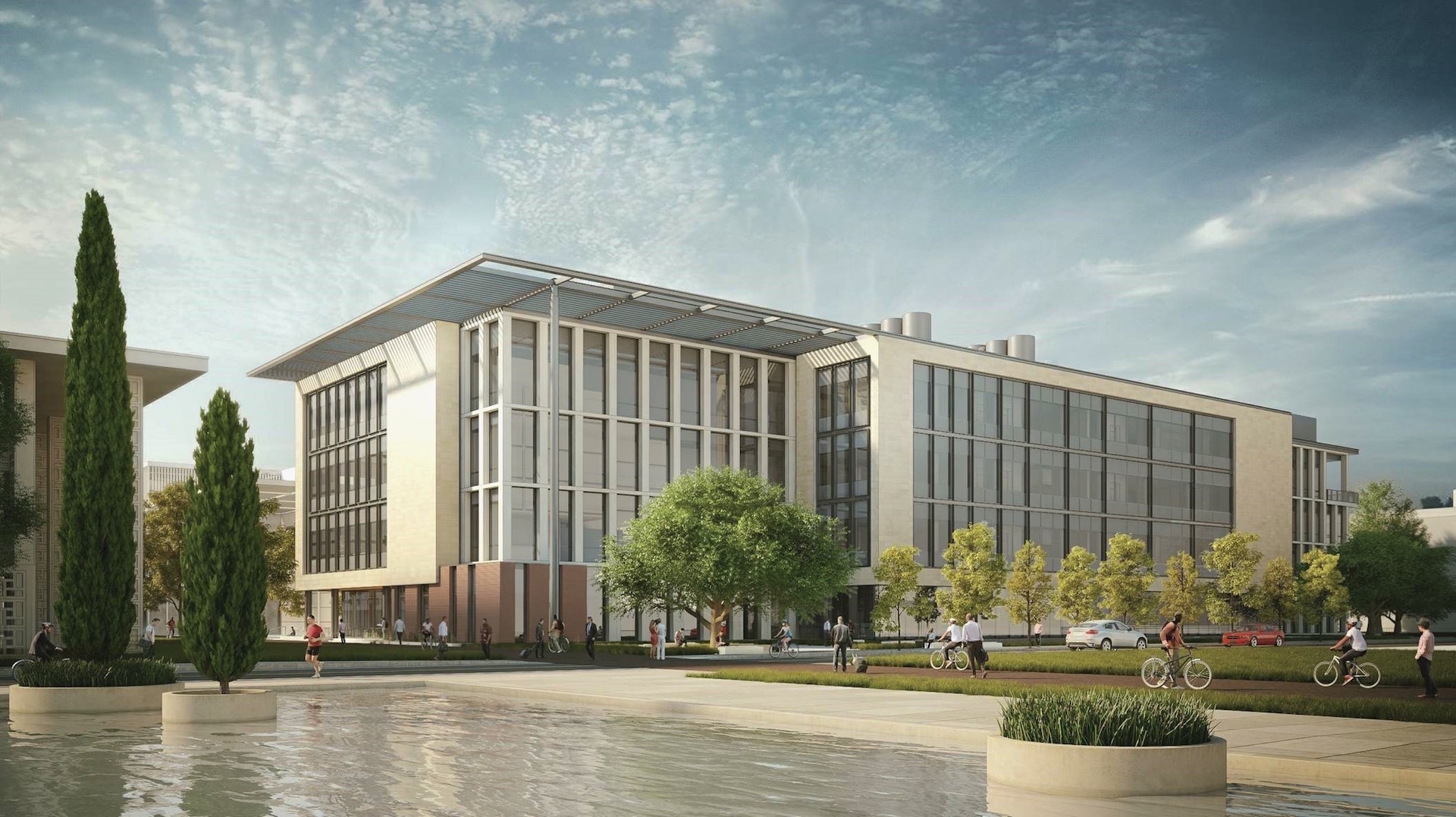 A modern academic building exterior and its surrounding campus on a sunny day.