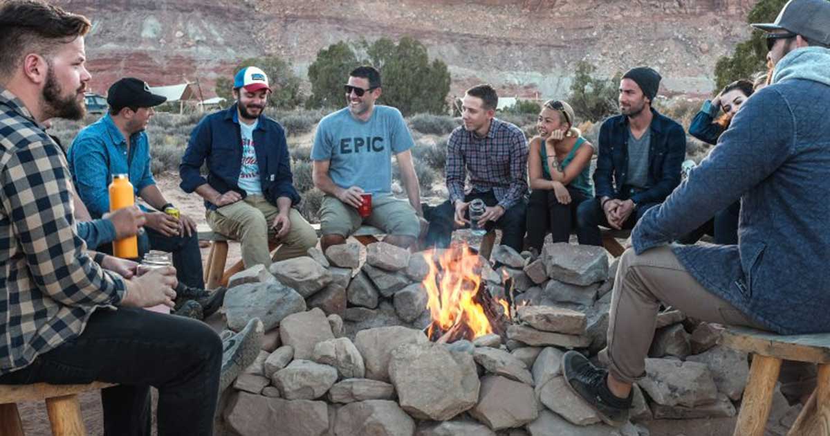 a group of people around a campfire laughing