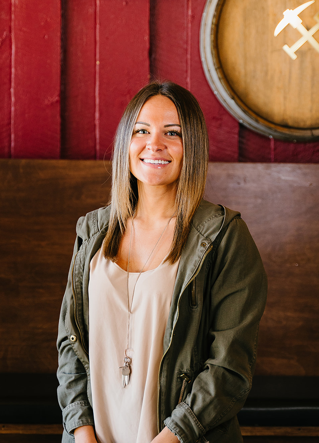 Carboy Tasting Room Manager, Kristen Kahl, standing in front of wine barrels