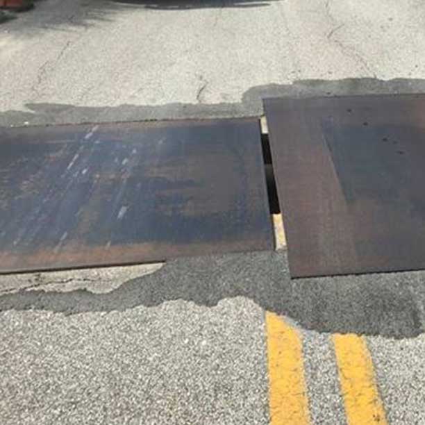 Steel plates covering construction zone holes in road.