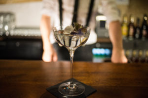 Dry martini on bar with edible flower garnish