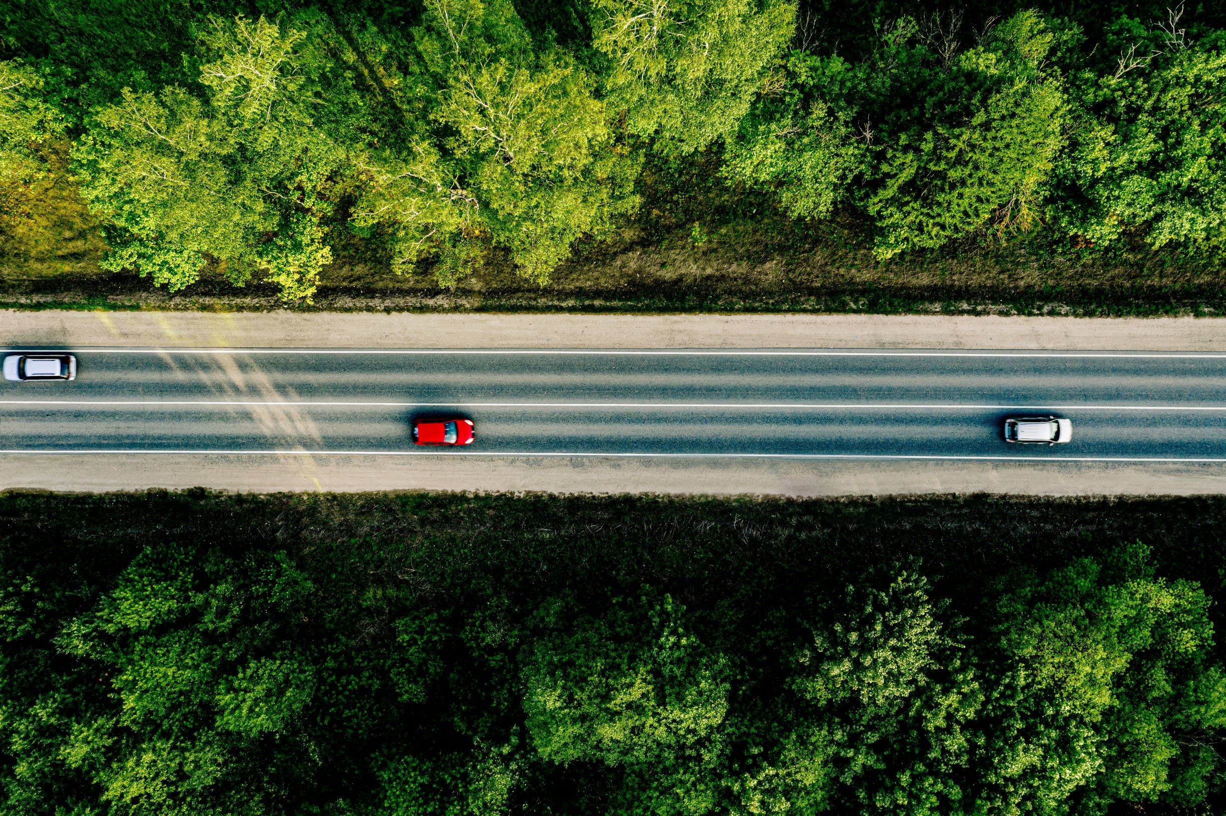 red car driving on road