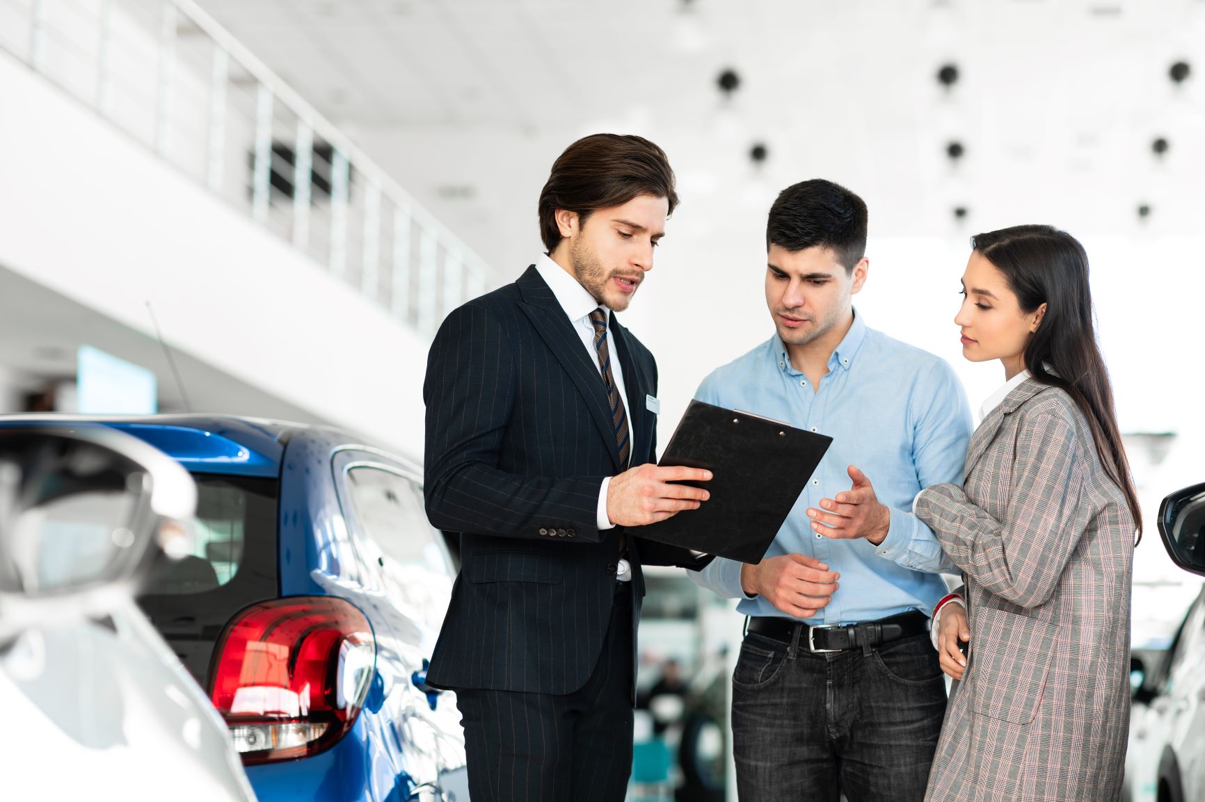young couple with car salesman