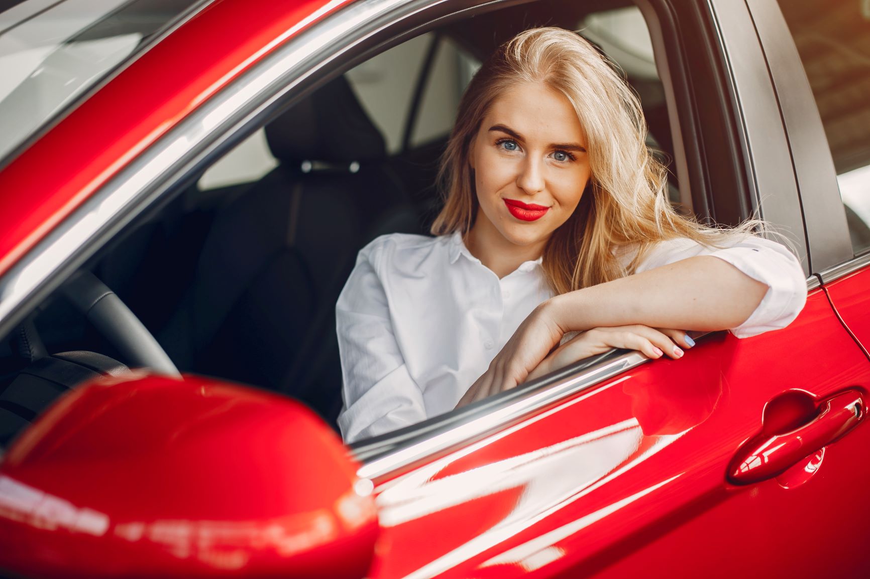 Blonde hair girl in red car