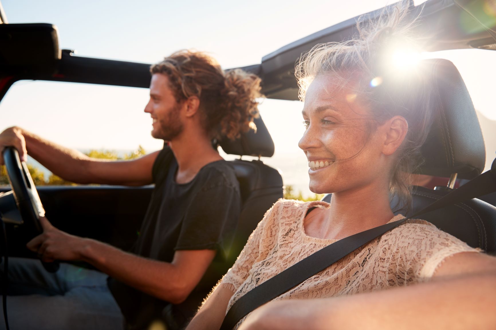 Couple driving car with top down