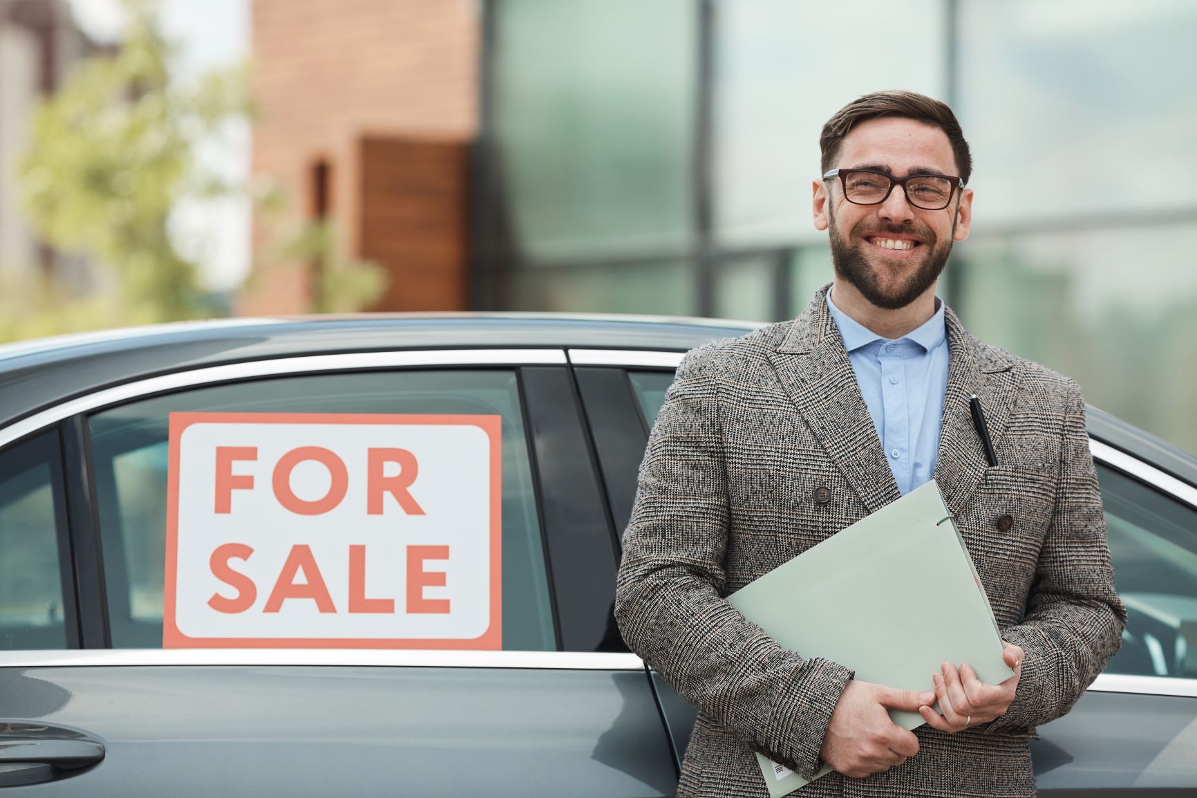 man standing in front of a car for sale