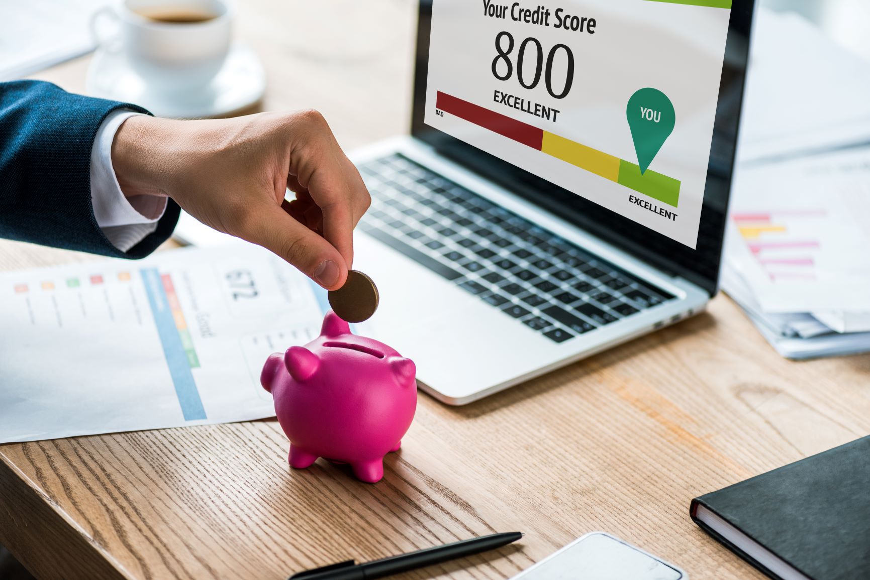 Piggy bank in front of credit score computer
