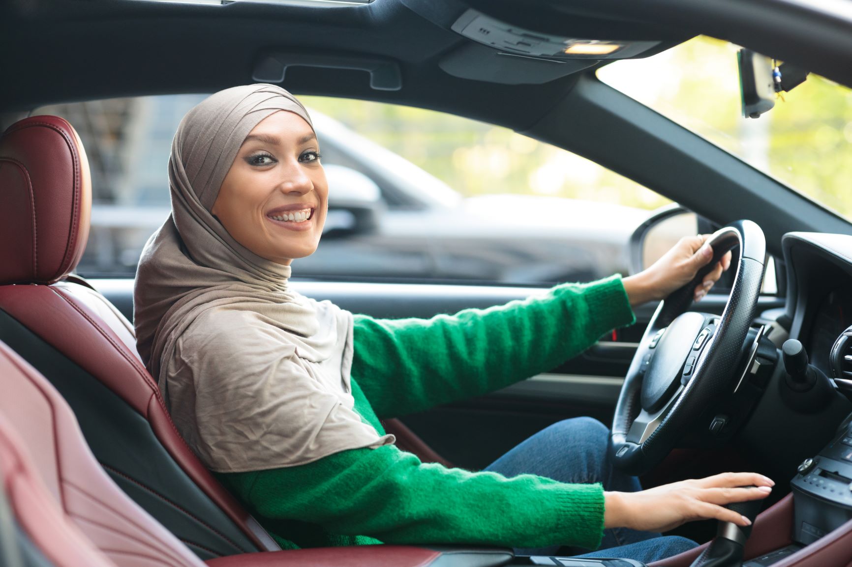 muslim woman driving and smiling