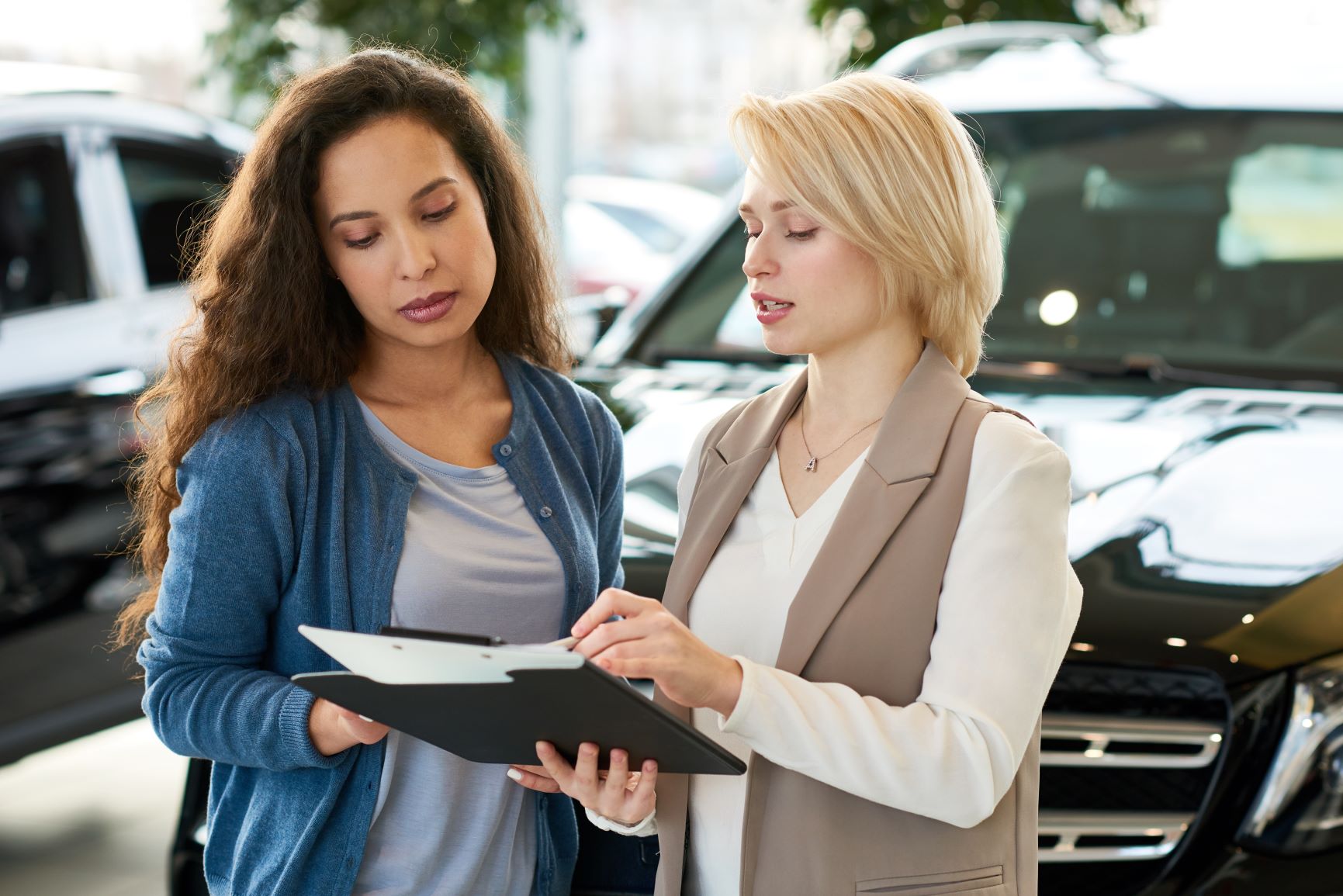 two women going over car paperwork